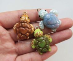 three little turtle figurines are sitting in someone's hand, one is holding the other