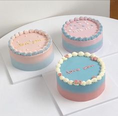 three cakes sitting on top of a white table