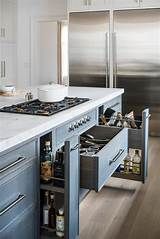 an open drawer in the middle of a kitchen counter with stainless steel appliances and cabinets