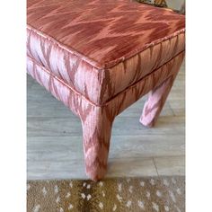 an upholstered pink bench on the floor