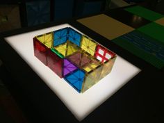 a colorful rubik cube sitting on top of a white table next to other colored blocks