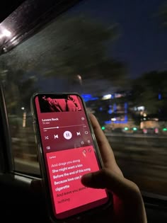 someone is using their cell phone to record music on the road at night time,