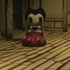 a cartoon character sitting on top of a red object in the middle of a room