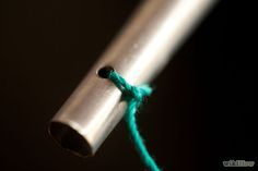 the end of a metal pole with a green string