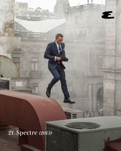 a man in a suit and tie jumping over a rooftop