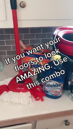 a red mop sitting on top of a kitchen counter next to other cleaning supplies