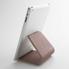 an ipad with a wooden stand on it's back side, in front of a white background