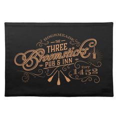 the three brooms pub and inn placemat in black with gold lettering on it