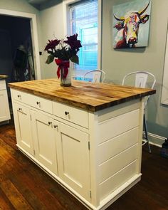 a kitchen island with flowers in a vase on top