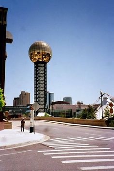 a man standing on the side of a road next to a tall tower with a domed top