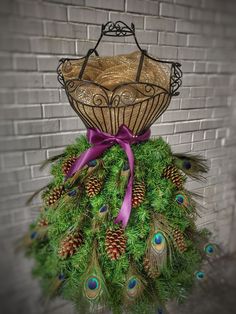 a dress made out of pine cones and feathers with a purple bow on the top