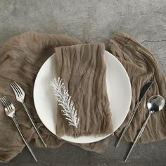 a white plate topped with a piece of cake next to silverware