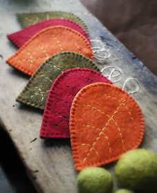 four felt hearts sitting on top of a piece of wood with the word love written in spanish