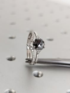 a diamond ring sitting on top of a piece of metal with lots of diamonds around it