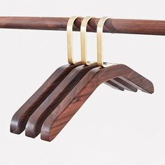 three wooden clothes hangers on a rail