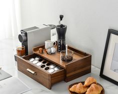 a wooden tray with coffee cups and pastries on it next to a cup holder