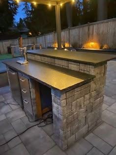 an outdoor kitchen with lights on the outside