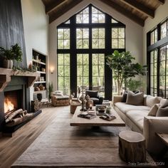 a living room filled with furniture and a fire place in front of a large window