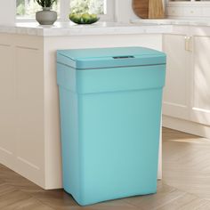 a blue trash can sitting in the middle of a kitchen