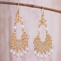 two pairs of gold earrings with pearls hanging from them