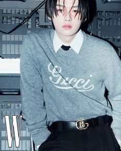 a young man wearing a sweater and tie in front of a computer equipment background with the word w on it