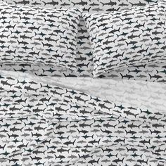 an image of a bed with shark print on the sheets and pillow cases in black and white