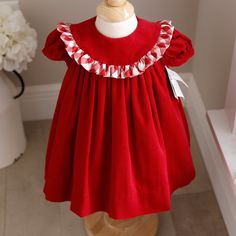 This Adorable Little Red Dress By Bailey Boys Is A Classic!!! The Dress In Done In A Gorgeous Deep Red And Is Made Of 100% Cotton, Pin Wale Corduroy- Super Soft And Cuddly! The Float Stlye Dress Has An Oversized Collat That Is Trimmed In A Beautiful Red And White Buffalo Plaid Ruffle. The Short Puff Sleeves Have A 1/2" Matching Corduroy Band For A Tailored Look. The Front And Back Top Have A Yoke, The Back Having A 2 Button Closure. The Dress Is Lined With A White Slip And Has A Small Tier Of Tu Christmas Cotton Dress With Ruffles, Red Christmas Playtime Dress, Cute Fitted Red Holiday Dress, Cute Red Holiday Dress, Cute Red Holiday Dresses, Cute Red Dress For Dress-up Occasions, Red Cotton Holiday Dress, Cute Red Festive Dress, Cute Cotton Holiday Dresses