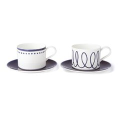 two cups and saucers with designs on them