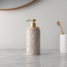 a marble soap dispenser and toothbrush holder on a white countertop