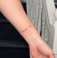 a person's hand with a small tattoo on the left side of their wrist