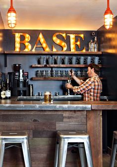 a man is sitting at the bar with two stools