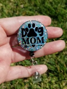 a person holding a dog mom badge in their hand