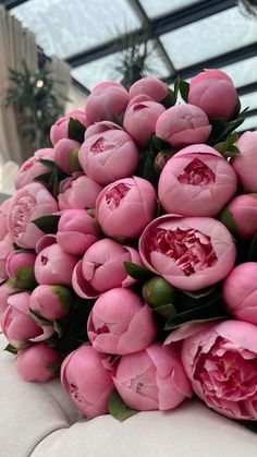 a bouquet of pink flowers sitting on top of a couch