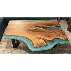 a coffee table made out of wood and blue glass in the shape of a wave