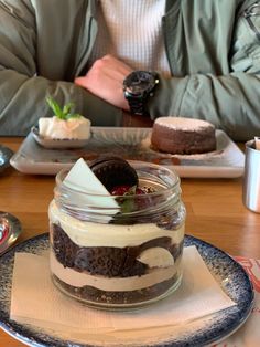 a man sitting at a table with desserts in front of him on his plate