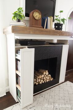 a fireplace with logs and a clock on top