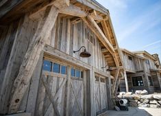 an old wooden building with two doors on each side and a light hanging from the roof