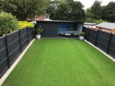 a backyard with artificial grass and fenced in area