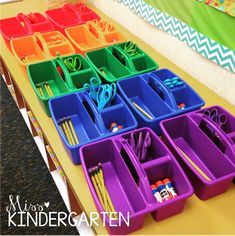 several trays with scissors, pencils and other office supplies on top of a table