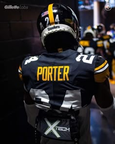 the back of a football player's uniform in a locker room with other players