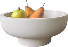 a white bowl with some pears and two oranges in it on a white background