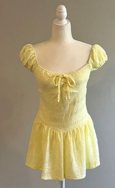 Illuminate the warm seasons with our stunning yellow lace mini dress. Effortlessly chic and versatile, this dress is perfect for creating casual looks that radiate with spring and summer vibes. The vibrant yellow hue instantly brightens any outfit, while the delicate lace adds a touch of elegance and femininity. The drop waist and sleeve caps bring a unique and fashionable twist to this classic silhouette, giving it a modern and trendy appeal. Whether you're attending a garden party, enjoying a Yellow Lace, Stylish Outfit, Strapless Tops, Lace Mini Dress, Classic Silhouette, Drop Waist, Yellow Dress, Top Dress, Dresses Xs