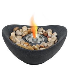 a bowl shaped fire pit with rocks around it