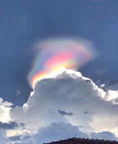 a rainbow appears in the sky above some clouds