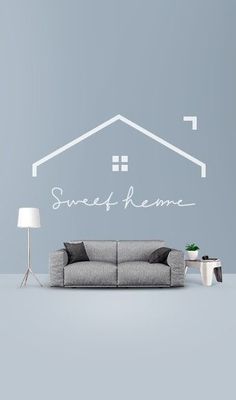 a living room with a couch, lamp and wall decal that says sweet home