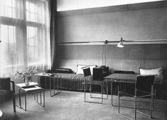 a black and white photo of a living room with two couches, chairs, tables and lamps