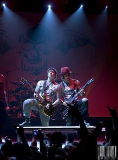 two men on stage with guitars in front of them