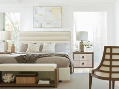 a bedroom with a bed, nightstands and two chairs