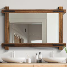 a bathroom with two sinks and a mirror on the wall above it that is made out of wood