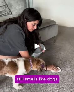 a woman is playing with her dog on the floor